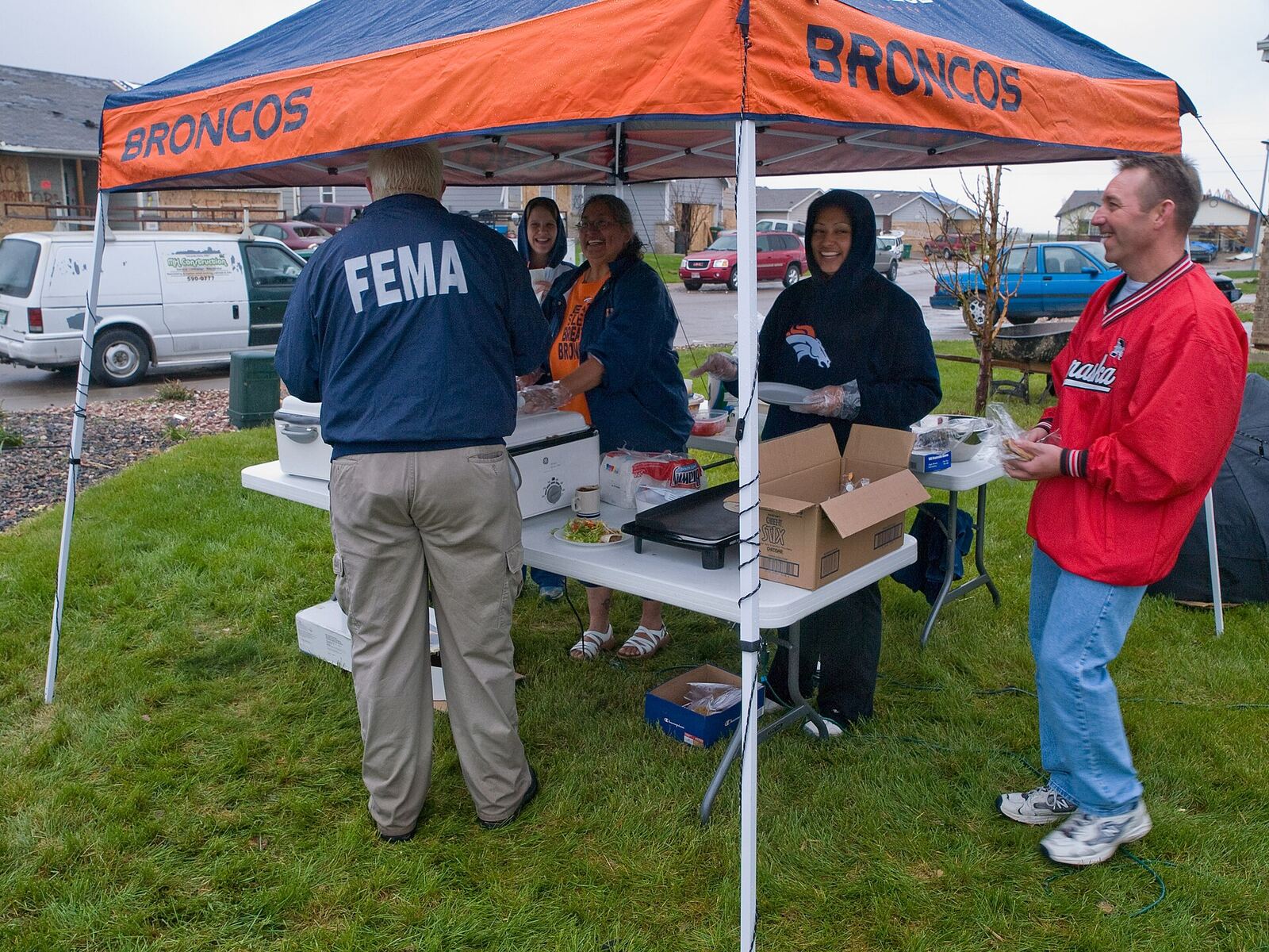 Disaster Relief | The Life After Tragedy FEMA personnel distribute supplies under a Denver Broncos tent, providing disaster relief to those in need.