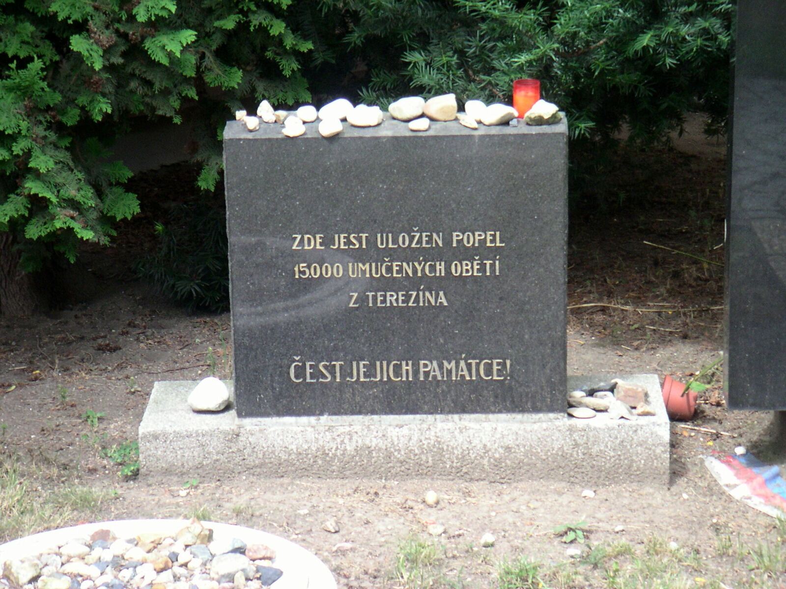 A dark memorial stone in Prague marks the final resting place of ashes from victims of Terezin concentration camp, honoring.